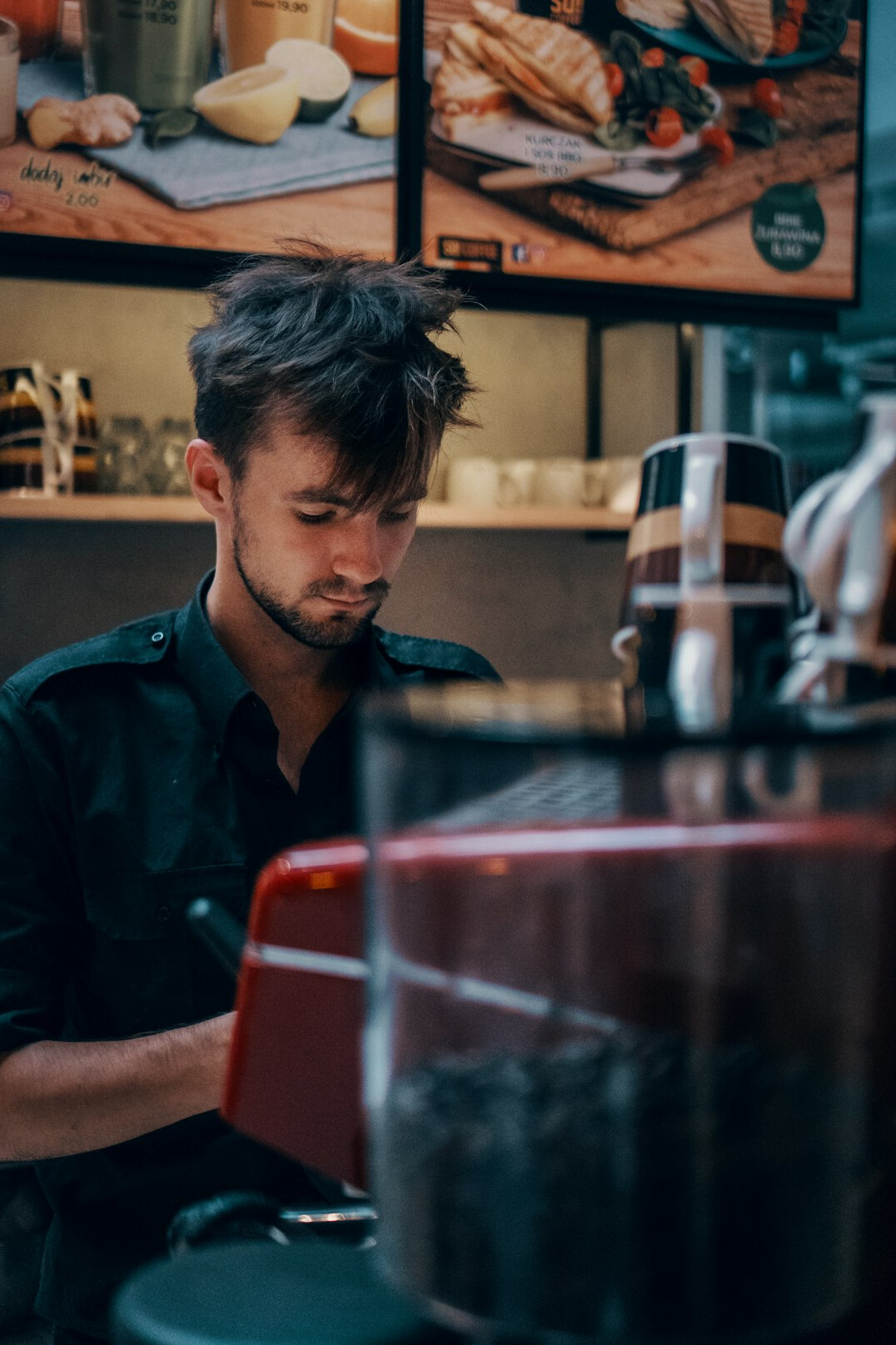 Writer typing an article on a laptop at a cafe table